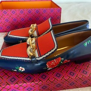Stylish new Tory Burch shoes with a gold statement piece on them.